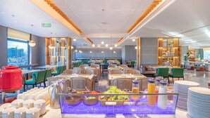En modern restaurang med en buffé, sittplatser och utsikt över staden.