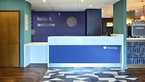 A reception desk with a clock and a "hello & welcome" sign. - Travelodge Derby Pride Park (Derby)
