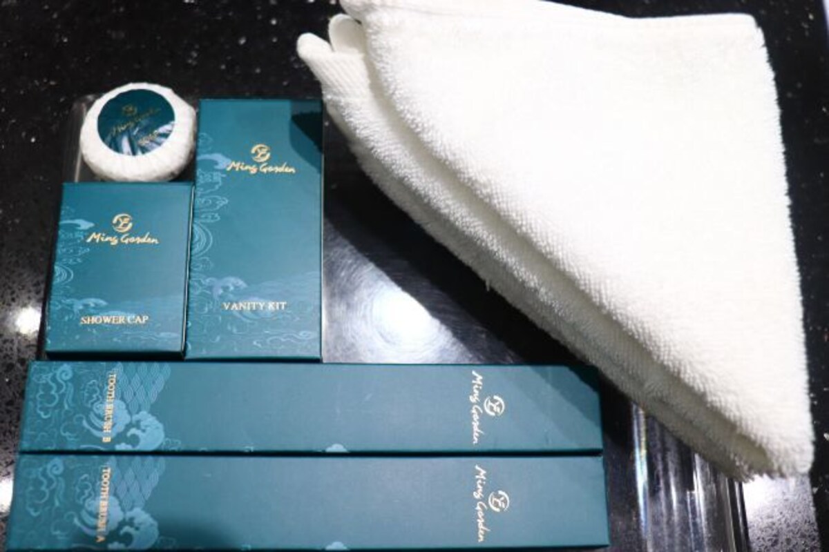 A set of bathroom amenities including a shower cap, vanity tray, and toothbrushes, arranged on a countertop.