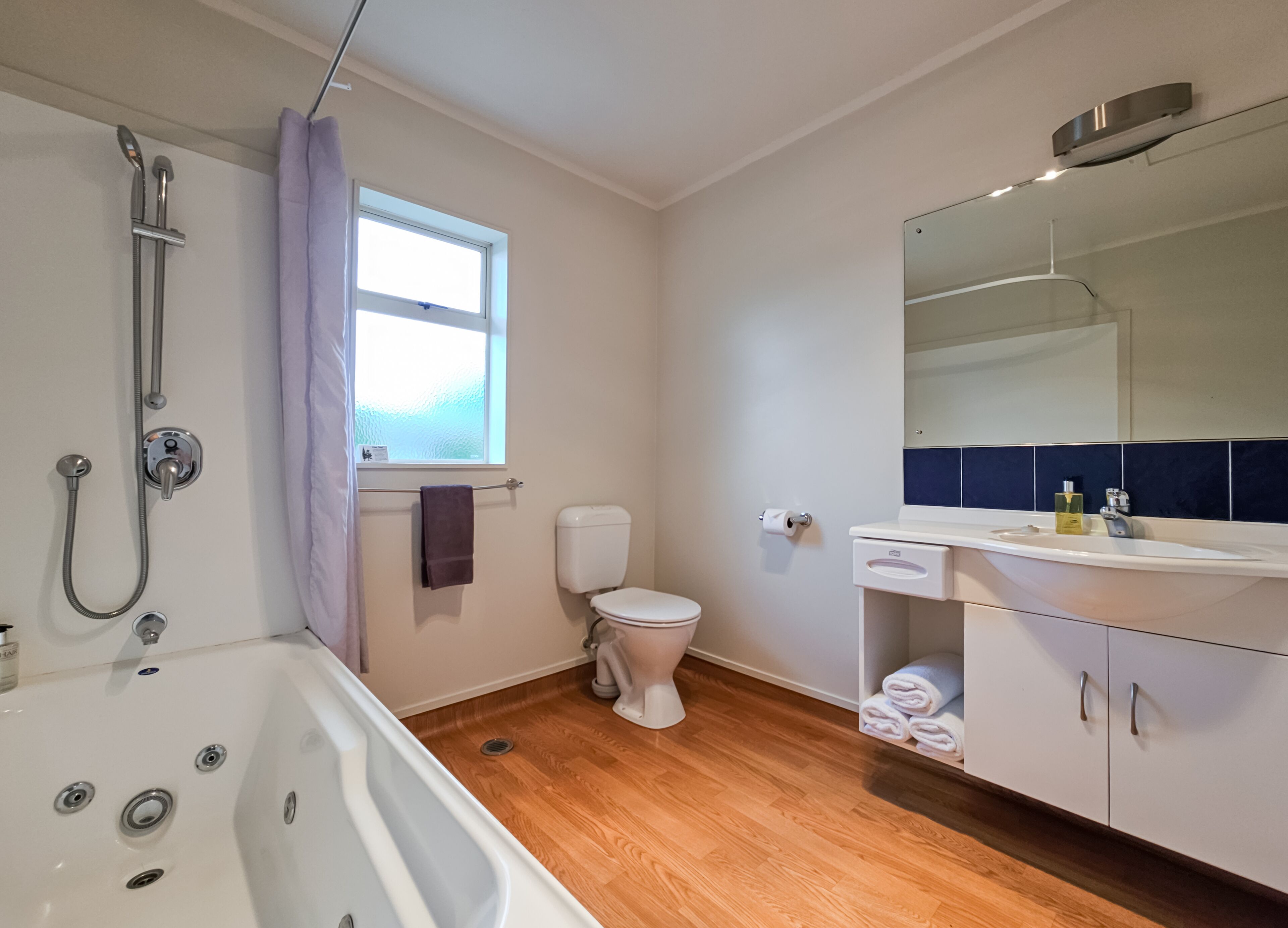 A modern bathroom with a shower, toilet, and bathtub.