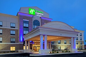 A Holiday Inn Express & Suites building with a covered entrance and a brick facade.
