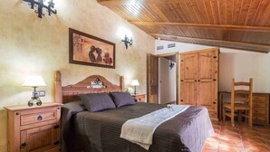 A bedroom with a wooden bed, two bedside tables with lamps, a wooden wardrobe, and a chair. - Sol de Taberno (Taberno)