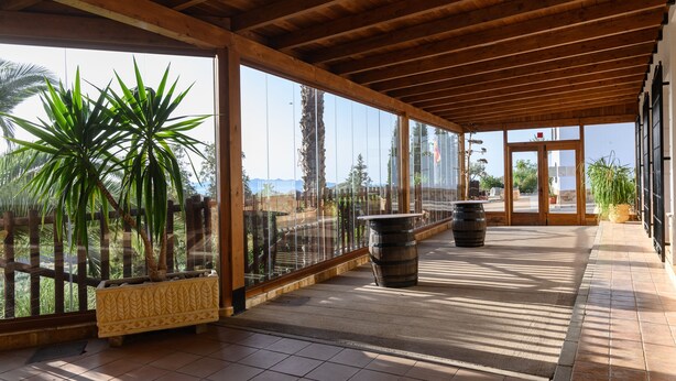 A covered outdoor area with wooden beams, potted plants, and a tiled floor. - Sol de Taberno (Taberno)