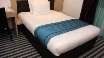 A hotel room with a bed, a desk, and a telephone.