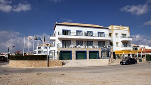 A multi-story hotel with balconies, a beach bar, and several flags. - Alagoa Azul Apartments (Castro Marim)