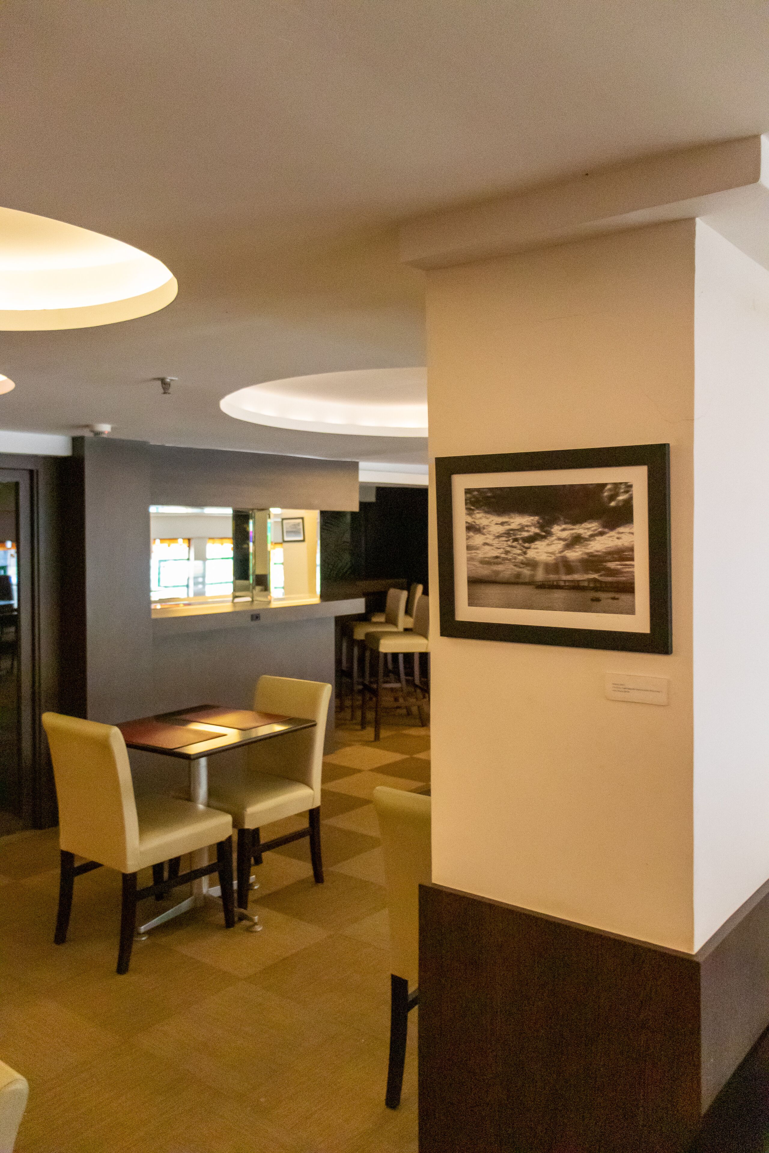 Una hall d'albergo con reception, area salotto e una fotografia incorniciata al muro.