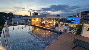 A rooftop pool area with a bar and seating, surrounded by city buildings. - Arosa Rio Hotel (Rio de Janeiro)