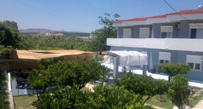 Un bâtiment avec un toit rouge, un balcon et une vue sur un paysage vallonné.