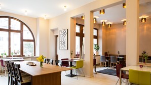 A modern dining area with a wooden table, multiple chairs, and a large window. - Hotel Villa Vinum Cochem (Cochem)