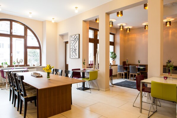 A modern dining area with a wooden table, multiple chairs, and a large window.