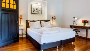 A neatly made bed with white linens, a dark wooden headboard, and two bedside lamps. - Hotel Villa Vinum Cochem (Cochem)