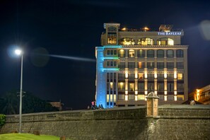 A hotel with a prominent sign reading "THE BAYLEAF" at night, featuring a modern architectural style with multiple windows and balconies.