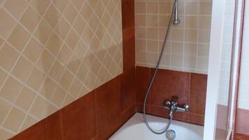 A bathroom with a bathtub, a shower, and a toilet.
