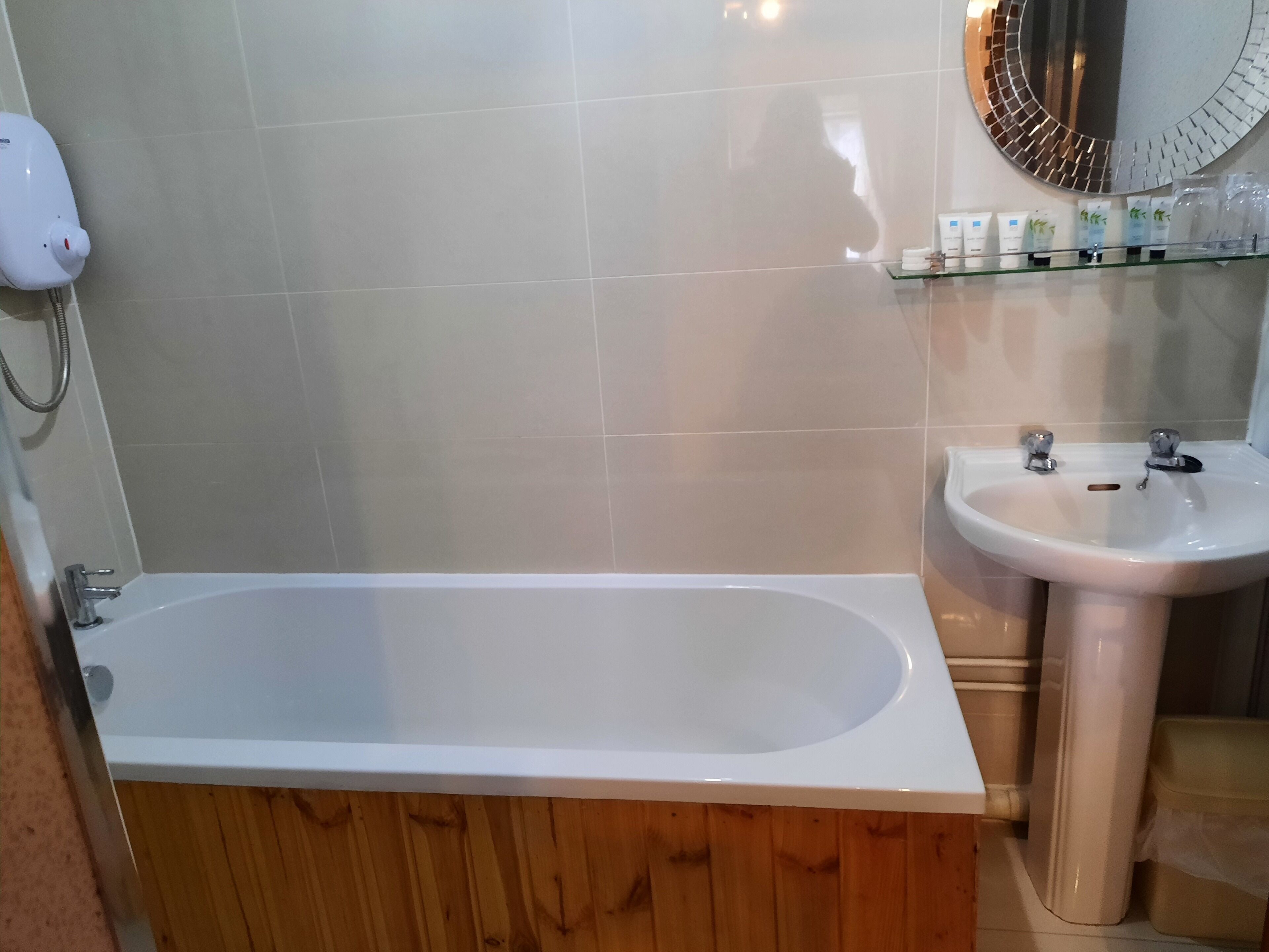 Ein Badezimmer mit einer Badewanne, einem Waschbecken und einem Spiegel.