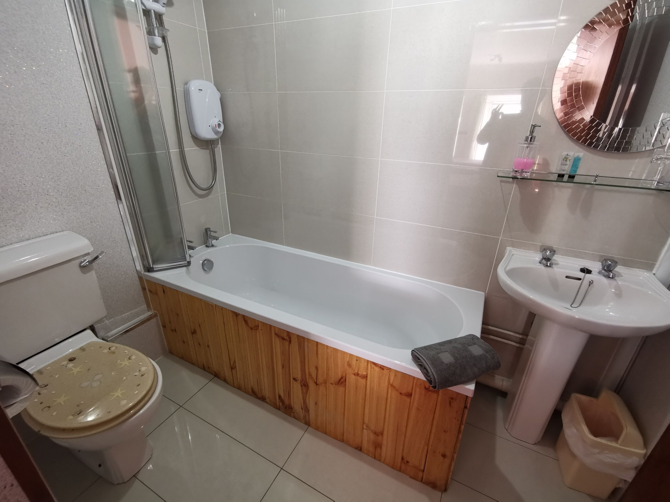 A bathroom with a bathtub, toilet, sink, and shower.