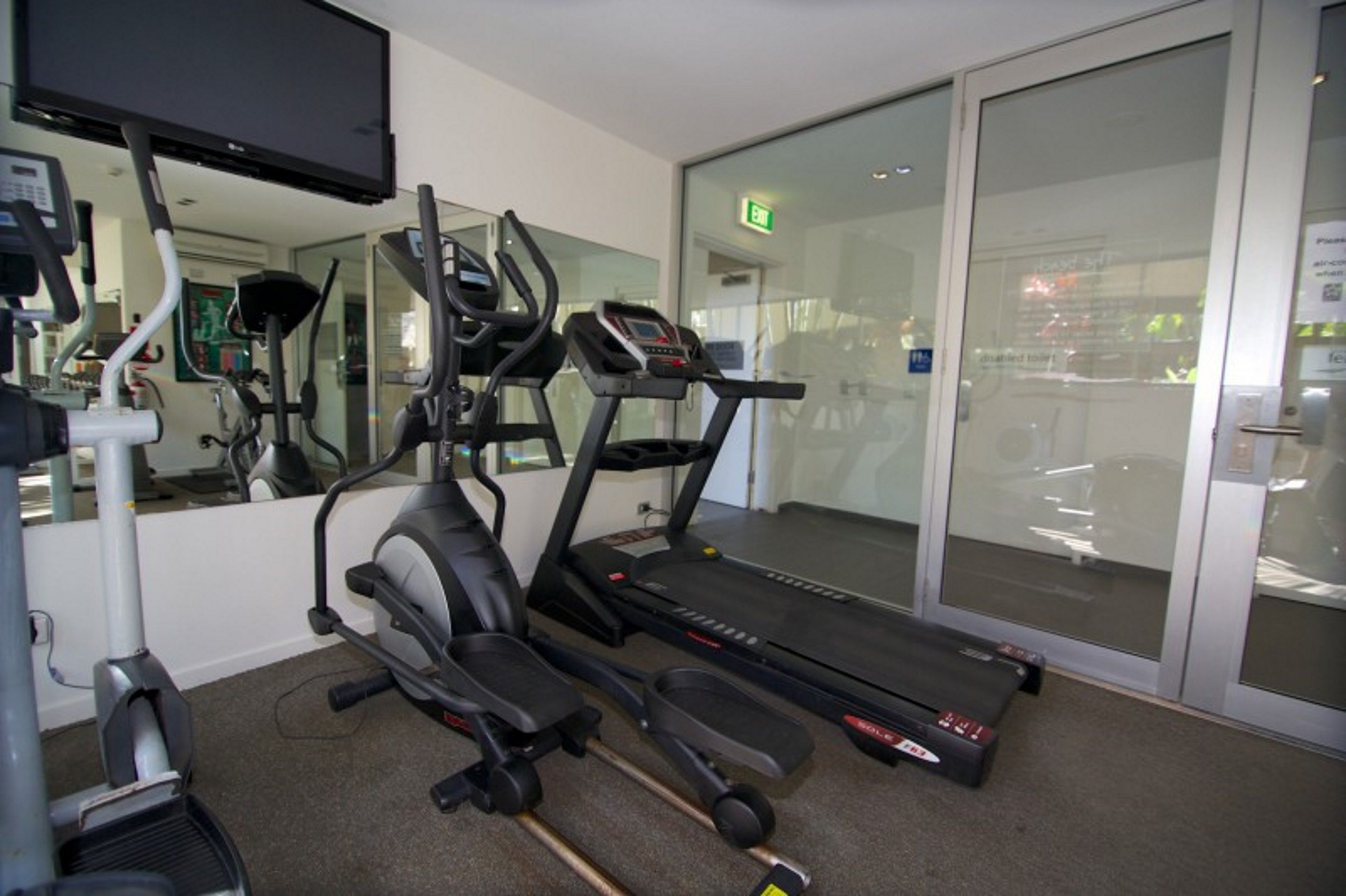Ein Fitnessstudio mit Laufbändern, Crosstrainern und Gewichtsmaschinen.