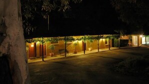 Un bâtiment doté d’un espace extérieur abrité, de plantes en pot et d’un banc.