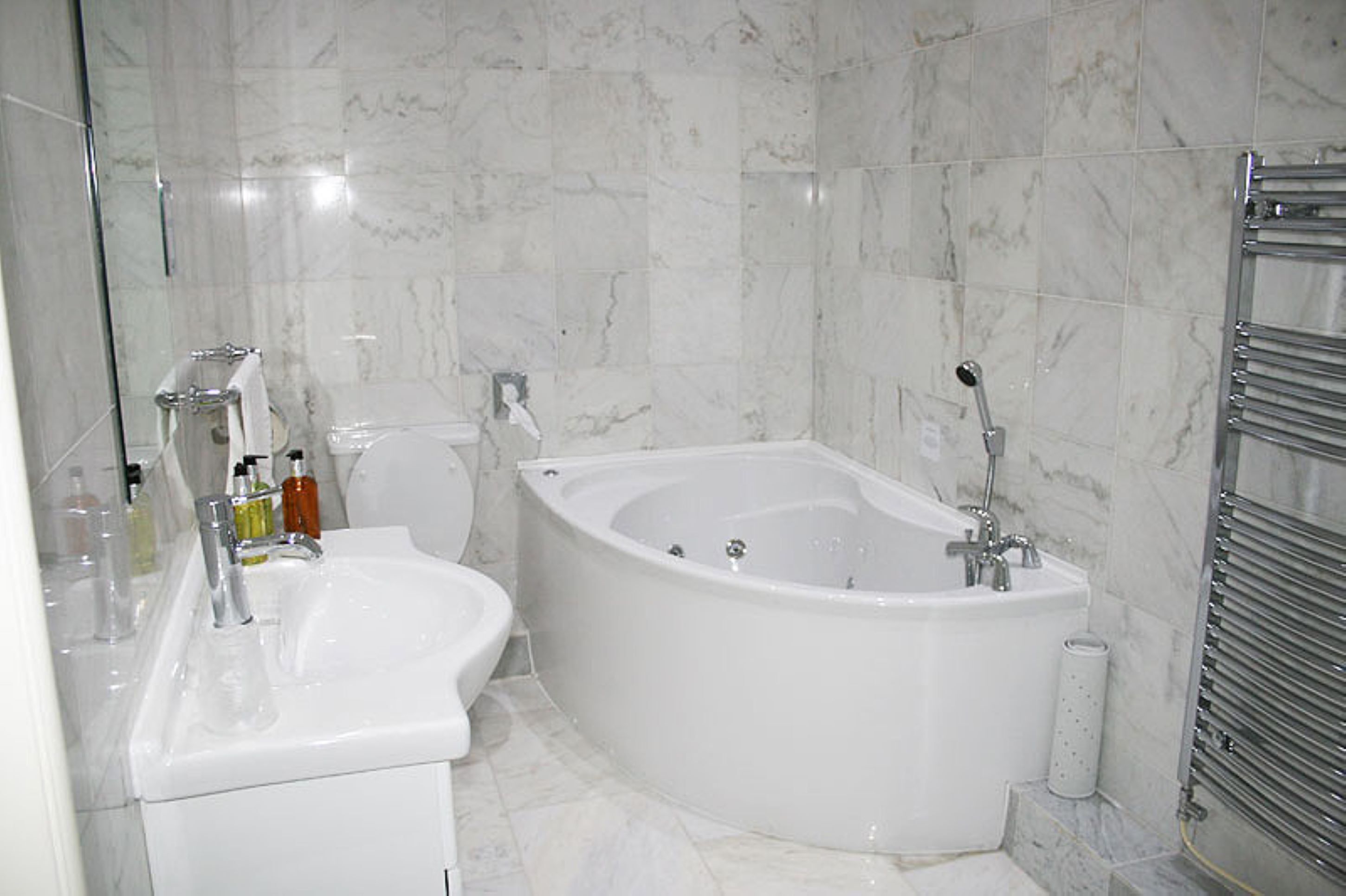 Une salle de bain avec une baignoire sur pieds, un lavabo et des toilettes.