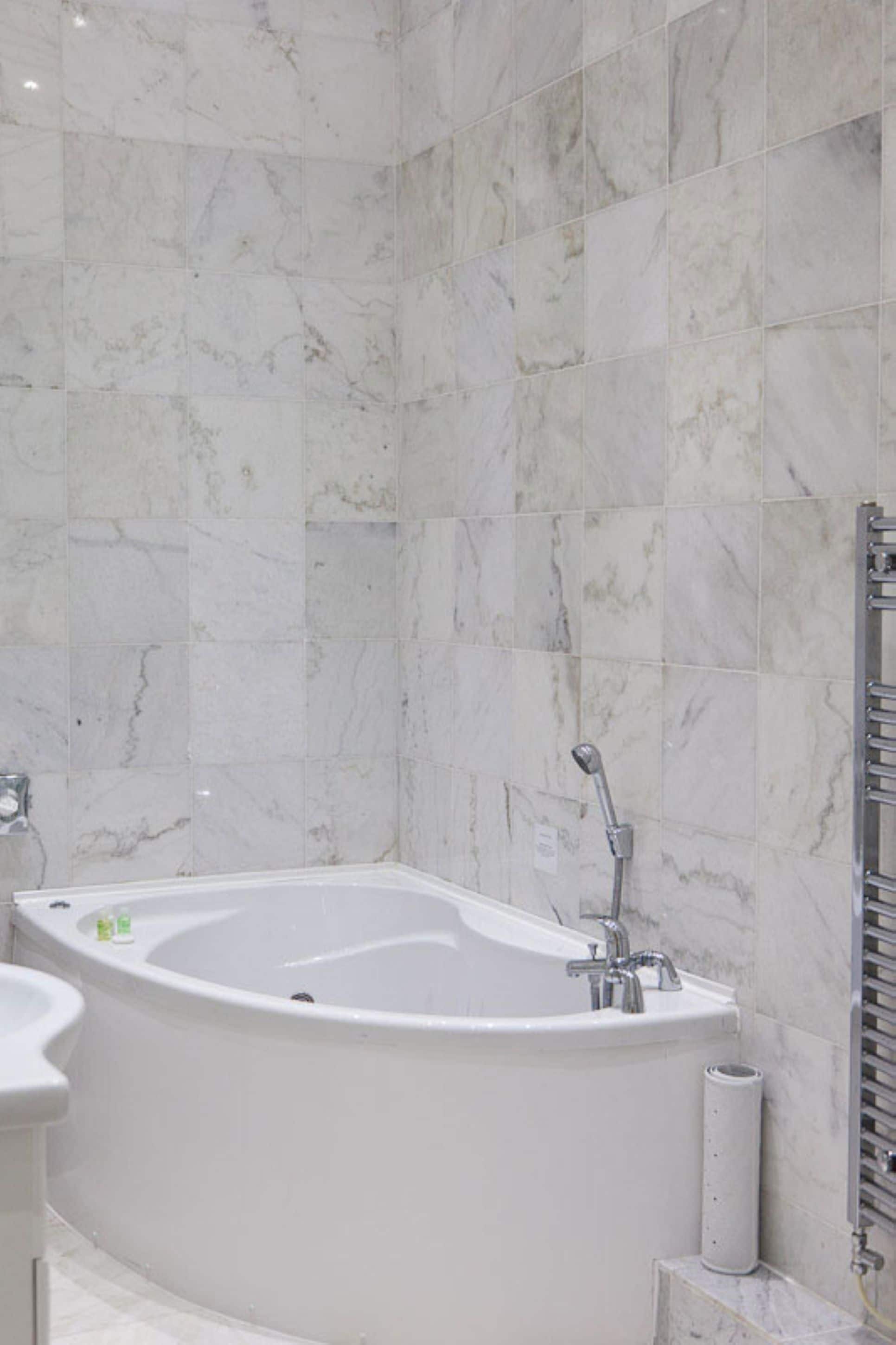 Un baño moderno con una bañera independiente, lavamanos e inodoro.