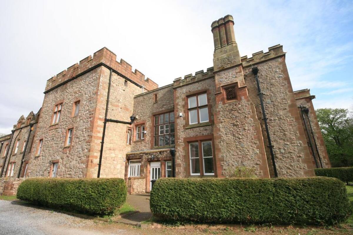 A stone building with multiple windows and a central entrance.