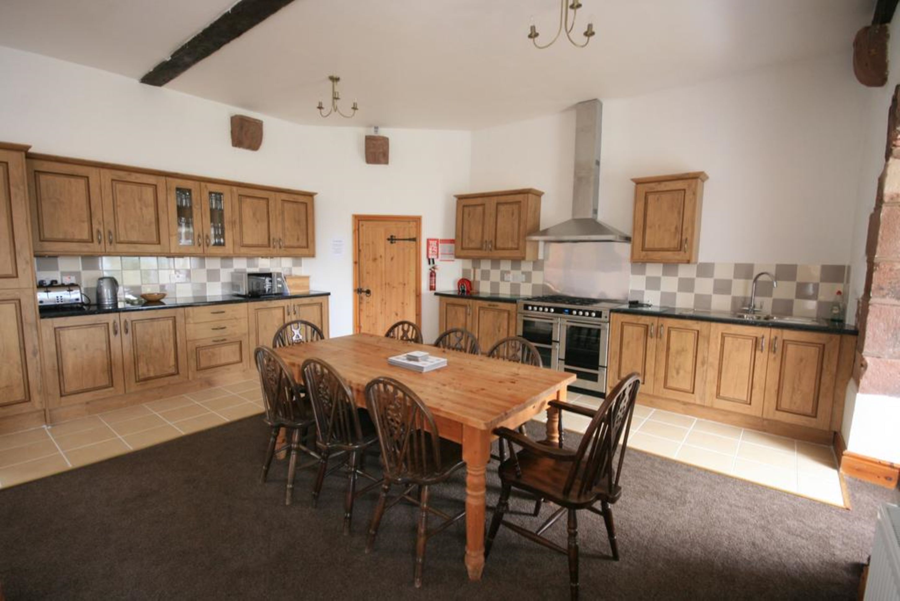 Una cocina con armarios de madera, una isla central y una mesa de comedor con sillas.
