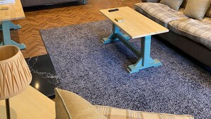Un salon confortable avec un canapé, une table basse et une lampe.