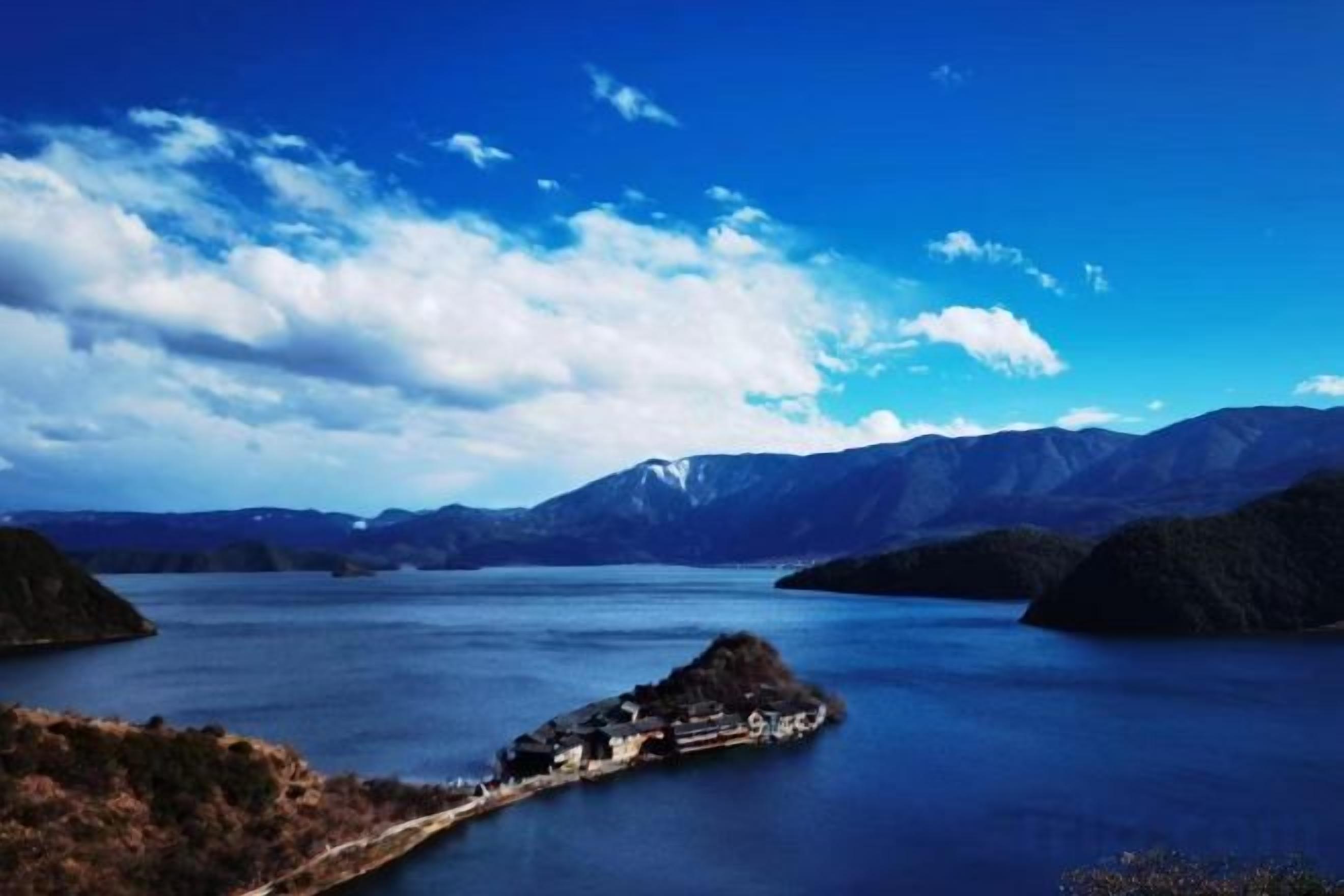 Un lago rodeado de montañas con una pequeña isla en el centro.