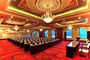A conference room with rows of chairs, a long table, and a chandelier. - Silver Lake Island Hotel At Lugu Lake, Yunnan (Lijiang)