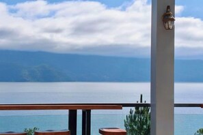 Un balcón con vista a un cuerpo de agua y tierra distante.