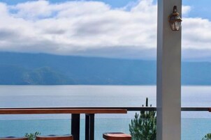 Un balcón con vista a un cuerpo de agua y tierra distante.