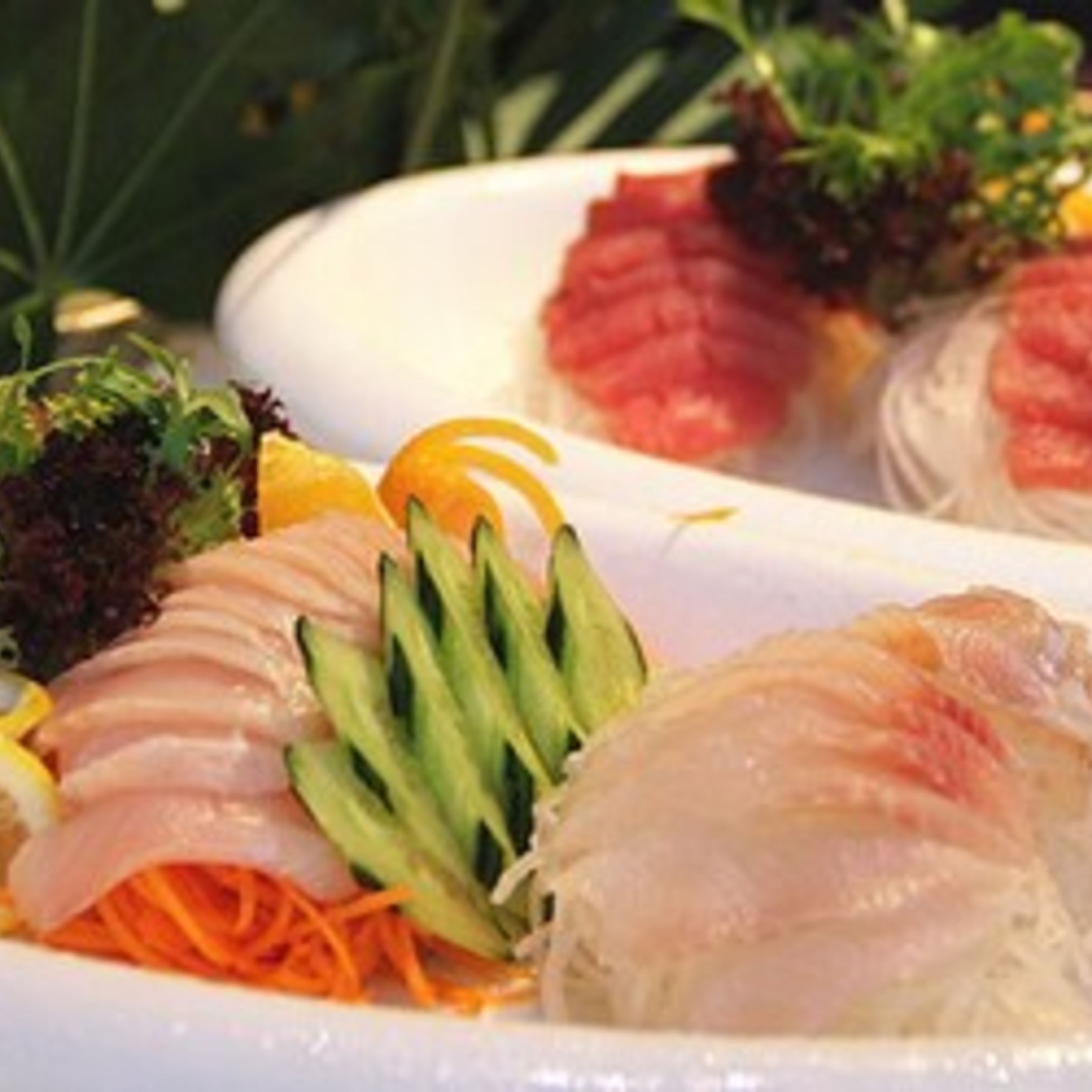 A plate of sushi with various toppings including avocado, cucumber, and possibly some fish.