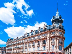 Un bâtiment historique doté d’éléments architecturaux raffinés, notamment un dôme imposant et de nombreux balcons.