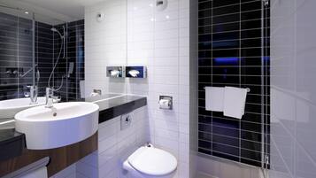 Une salle de bain moderne avec un double lavabo, des toilettes et un espace douche.