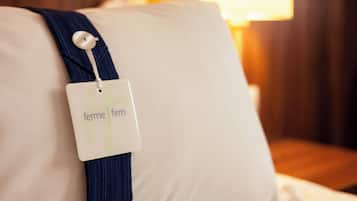 A pillow with a tag labeled 'ferme firm' attached to it.