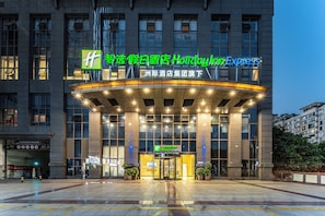 A Holiday Inn Express hotel entrance with a modern design, large windows, and a well-lit facade. - Holiday Inn Express Chongqing Guanyinqiao by IHG (Chongqing)