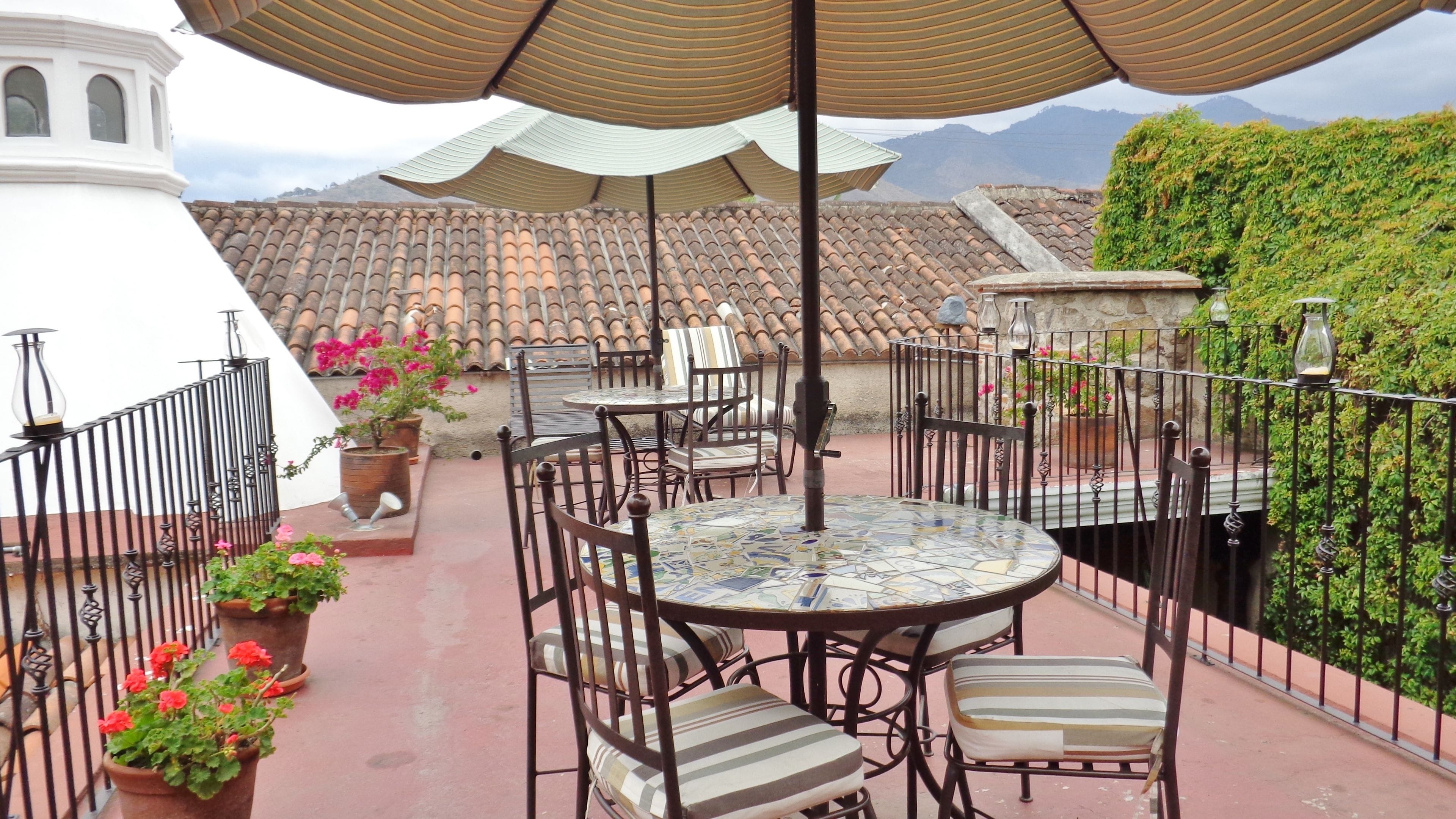 A terrace with a tiled roof, outdoor furniture, and potted plants.