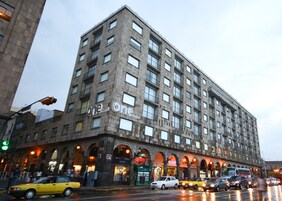 A multi-story hotel with a prominent 'One' sign, featuring a modern architectural design with a grid of windows and balconies.