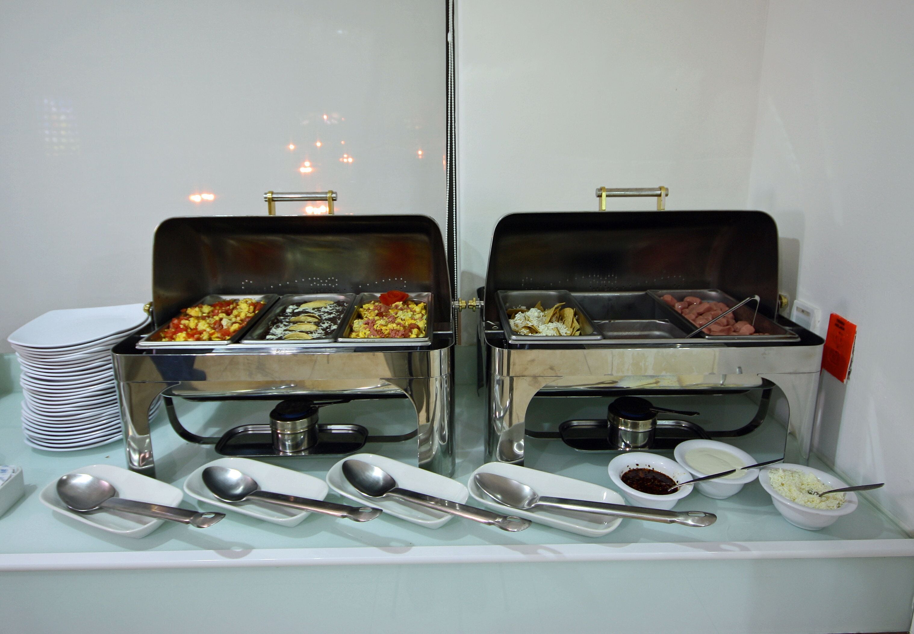 Una mesa de buffet con diversos alimentos y utensilios.