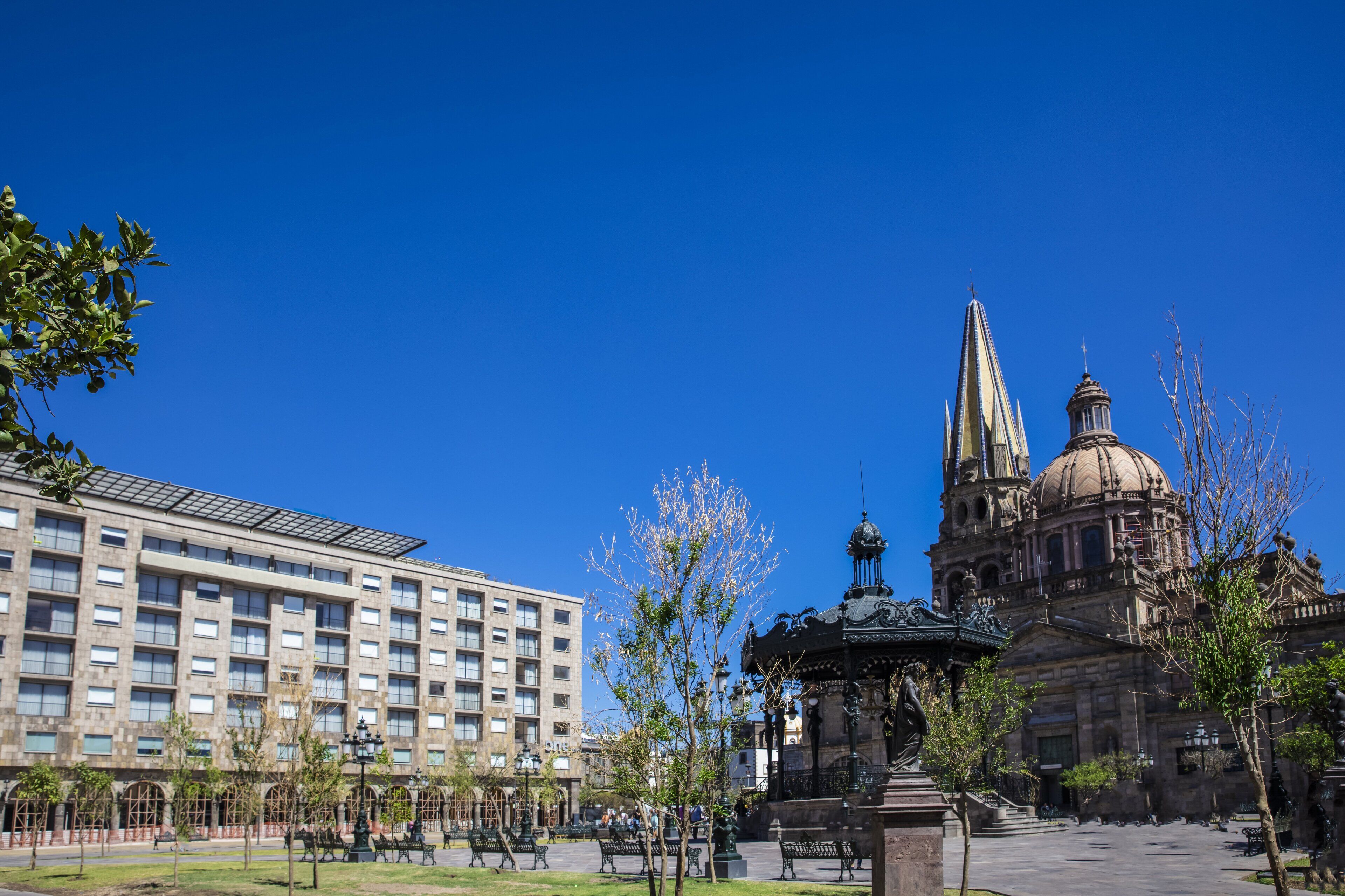 Un patio con un edificio grande, una fuente y una estatua.