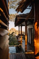 A wooden deck with a small pool, overlooking a mountainous landscape.