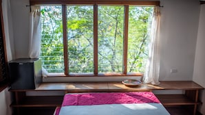 A room with a large window, a bed, a small table, and a television. - Aqua Oceanfront Hotel Resort (Tola)