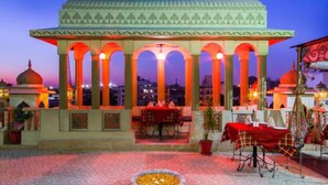 A traditional pavilion with multiple arches and a central dining area with tables and chairs. - Nahargarh Haveli (Jaipur)