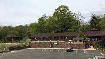 Un parking doté d’un belvédère, d’un patio couvert et d’un bâtiment en briques avec un toit en pente.