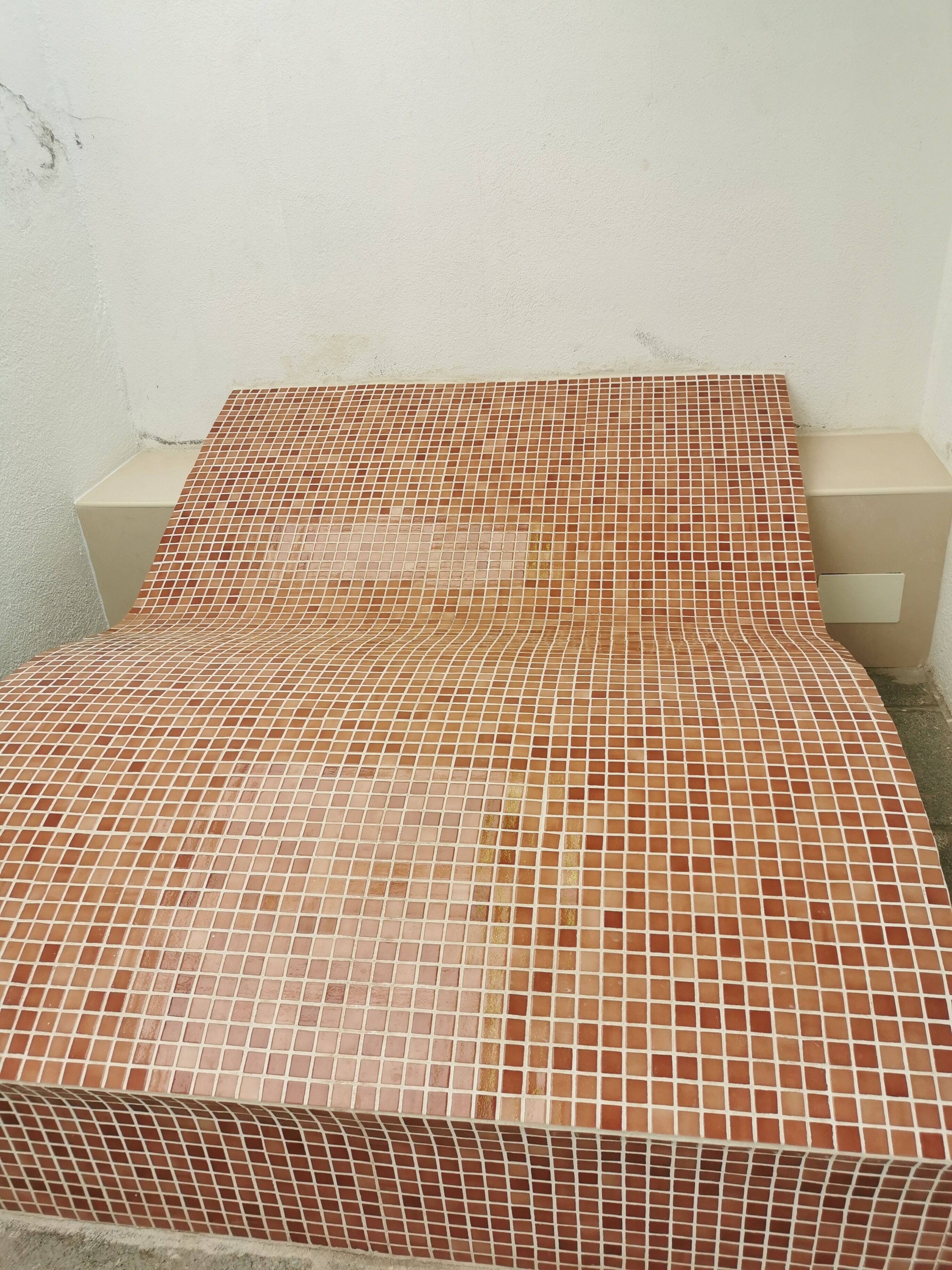 Un lit avec un matelas à motifs et un mur uni.