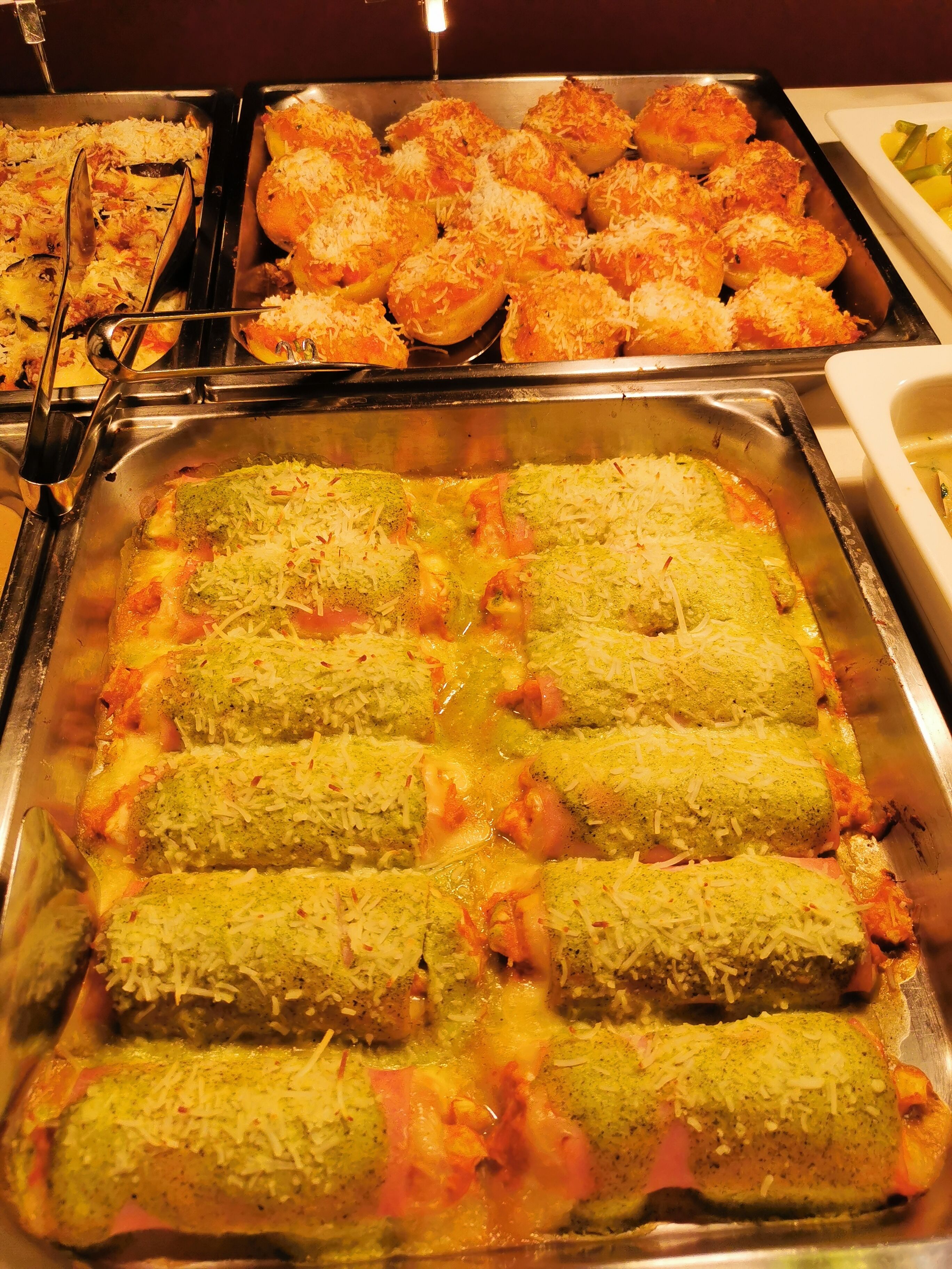 A buffet with various dishes including pasta, rice, and bread.