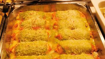 A buffet with various dishes including pasta, rice, and bread.