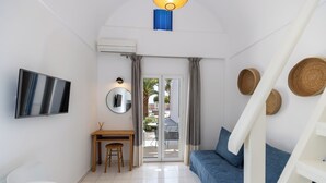 Ein modernes, gut beleuchtetes Zimmer mit Schreibtisch, Stuhl und einem blauen Sofa.