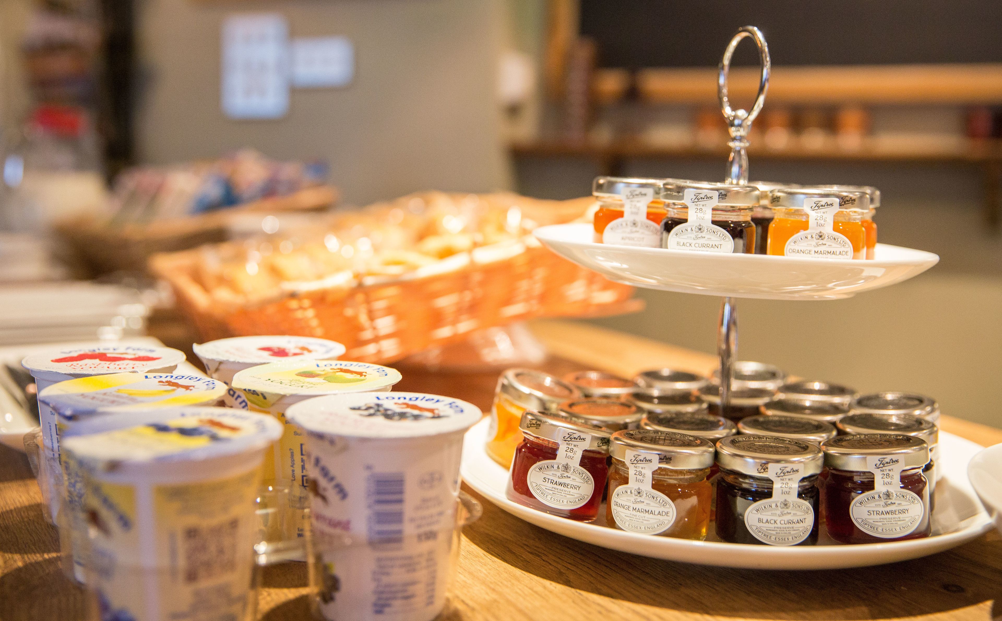 A display of food items including jars of jam and containers of yogurt.