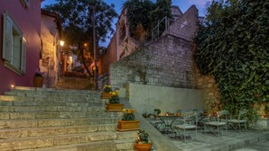A stone staircase leading to a terrace with outdoor seating and potted plants. - Grand Sarai Nafplio (Nafplio)