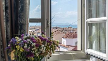 A window with a view of buildings and a mountain range.